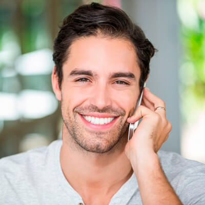 Man smiling and holding his cellphone to his ear